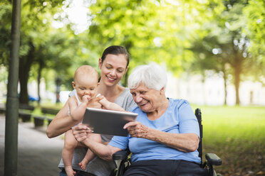 Großmutter, Tochter und Enkelin haben Spaß mit dem Tablet in einem Park - DIGF03210