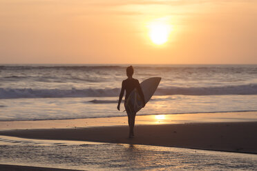 Indonesia, Bali, young woman with surfboard - KNTF00966