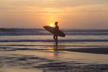 Indonesia, Bali, young woman with surfboard - KNTF00969