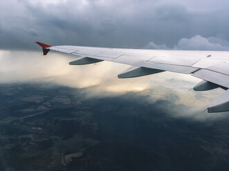 Blick auf die Tragfläche eines Flugzeugs, das in grauen Wolken am Himmel fliegt, Sofia, Bulgarien. - BZF00377