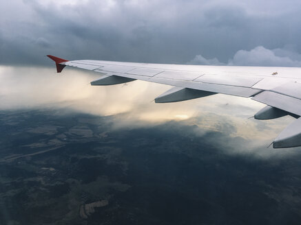 View to wing of airliner flying in gray clouds in the sky. Sofia, Bulgaria. - BZF00377