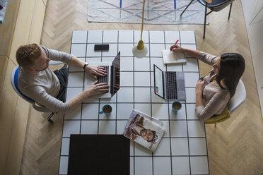 Couple with laptops working at home - MOMF00368