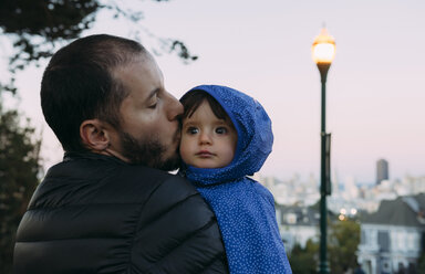 USA, Kalifornien, San Francisco, Vater küsst ein kleines Mädchen am Alamo Square am Abend - GEMF01840