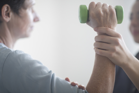 Physiotherapeutin und Patientin, Training mit Kurzhantel, lizenzfreies Stockfoto