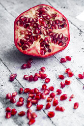 Sliced pomegranate and pomegranate seed on wood - SARF03454