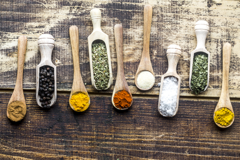 Spicies, curry, chilli, cinnamon, curcuma, garlic, parsley, oregano, salt and pepper on wooden spoons stock photo