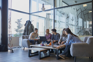 Group of friends sitting together in a cafe with laptop and drinks - ZEDF01039