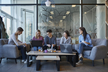 Group of friends sitting together in a cafe with laptop and drinks - ZEDF01040