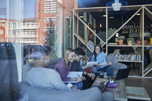 Gruppe von Freunden sitzt zusammen in einem Café mit Reflexion der Glasscheibe - ZEDF01042