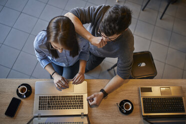 Top view of young woman and man in a cafe sharing a laptop - ZEDF01071