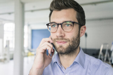 Porträt eines Geschäftsmannes mit Mobiltelefon - MOEF00644