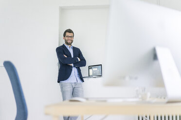 Portrait of smiling businessman standing in office - MOEF00659