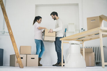 Couple moving into new home unpacking cardboard boxes - MOEF00679