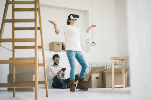 Couple in new home with woman wearing VR glasses stock photo