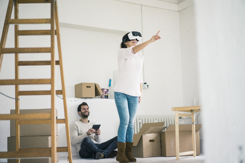 Ehepaar in neuem Haus mit Frau mit VR-Brille, lizenzfreies Stockfoto