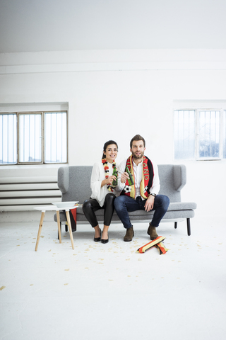 German football fan couple sitting on couch watching Tv stock photo