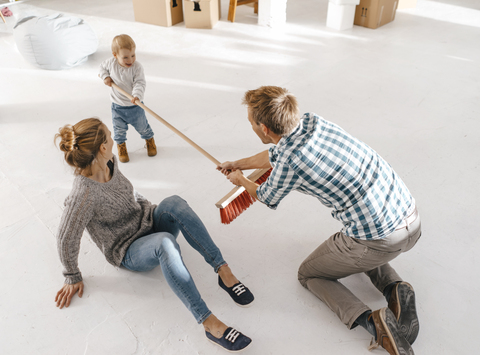 Vater und Tochter haben Spaß mit einem Besen auf einem Dachboden, lizenzfreies Stockfoto