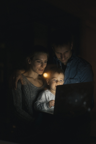 Family using laptop in the dark stock photo