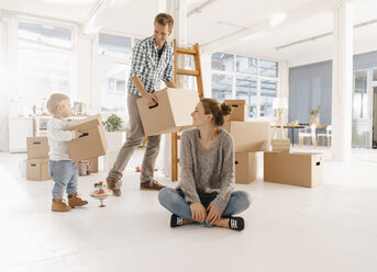 Glückliche Familie beim Umzug in ein neues Haus mit Vater und Tochter, die Kartons tragen - KNSF03402