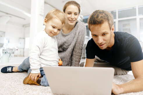 Familie benutzt Laptop auf dem Boden - KNSF03409