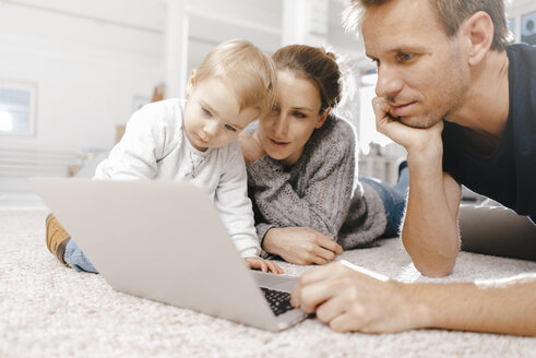 Familie benutzt Laptop auf dem Boden - KNSF03410