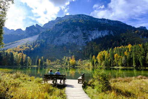 Deutschland, Bayern, Oberbayern, Chiemgau, Inzell, Frillensee, Wanderer sitzen auf Bank im Herbst - LBF01728