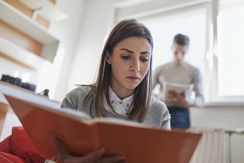 Student in dormitory reading book stock photo