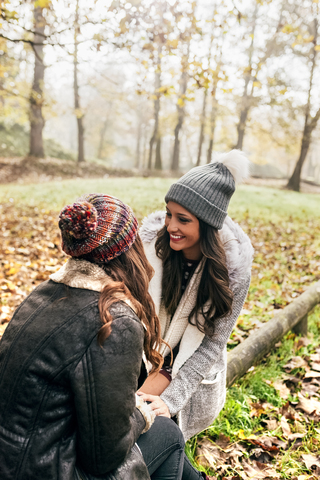 Zwei hübsche Frauen entspannen sich in einem herbstlichen Wald, lizenzfreies Stockfoto