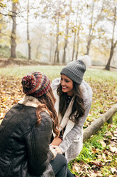 Two pretty women relaxing in an autumnal forest - MGOF03696