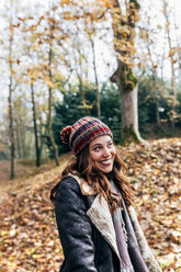 Porträt einer schönen glücklichen Frau in einem herbstlichen Wald - MGOF03698