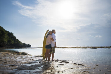 Zärtliches älteres Paar mit Surfbrettern am Strand - SBOF01041
