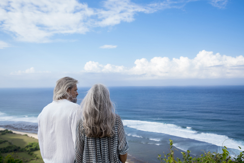 Älteres Paar mit Blick auf das Meer, Rückansicht, lizenzfreies Stockfoto