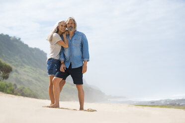 Affectionate senior couple standing on the beach - SBOF01069