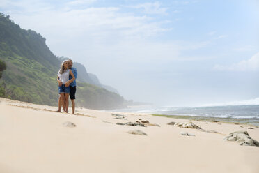 Affectionate senior couple standing on the beach - SBOF01070