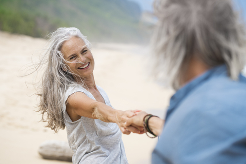 Handsome senior couple dancing on the beach stock photo