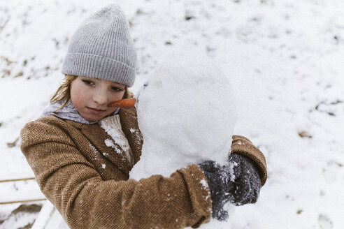 Boy hugging a snowman - KMKF00131