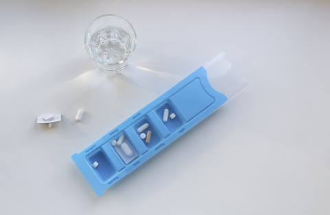 Tablettenkassette mit Tabletten, Glas Wasser, lizenzfreies Stockfoto