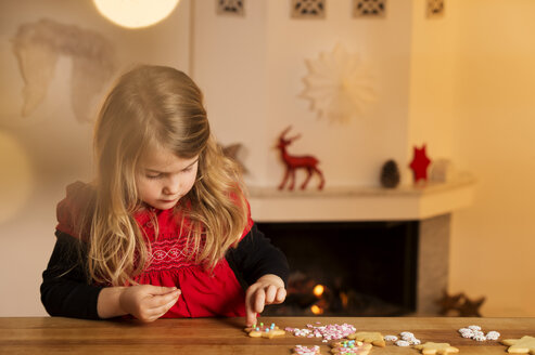 Kleines Mädchen garniert Weihnachtsplätzchen mit Hunderten und Tausenden - NEKF00003