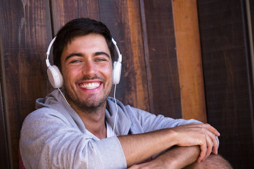 Portrait of happy young man wearing headphones - SIPF01917