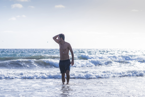 Junger Mann, der aus dem Meer kommt, lizenzfreies Stockfoto