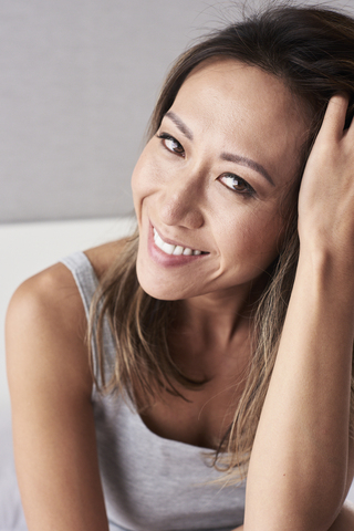 Portrait of smiling woman with head in hand stock photo