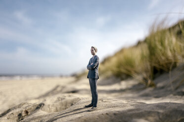 Geschäftsmann auf einer Sanddüne stehend, in die Ferne blickend - FLAF00015