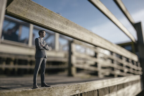 Businessman figurine standing on wooden stairs - FLAF00020