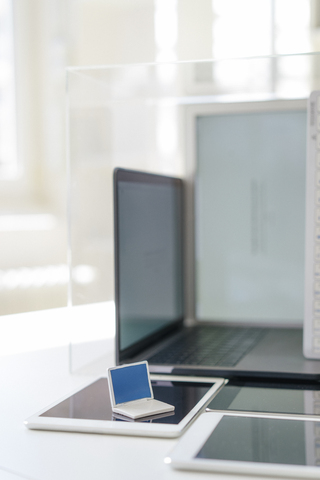 Miniatur-Laptop und mobile Geräte auf einem Schreibtisch, lizenzfreies Stockfoto