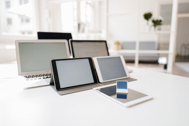 Miniature laptop and mobile devices on a desk - FLAF00044