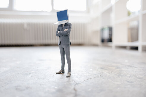 Businessman figurine with laptop head standing on concrete - FLAF00052