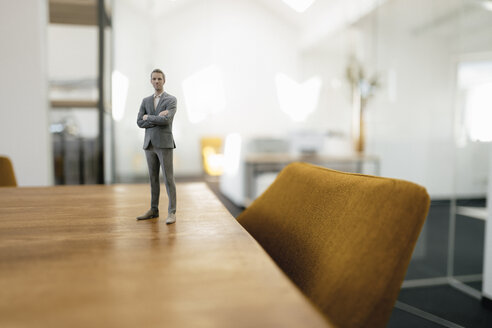 Businessman figurine standing on desk in modern office - FLAF00083