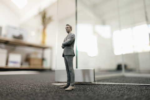 Geschäftsmann vor einer Glaswand im Büro stehend, lizenzfreies Stockfoto