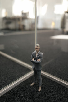 Businessman figurine standing between glass panes - FLAF00086