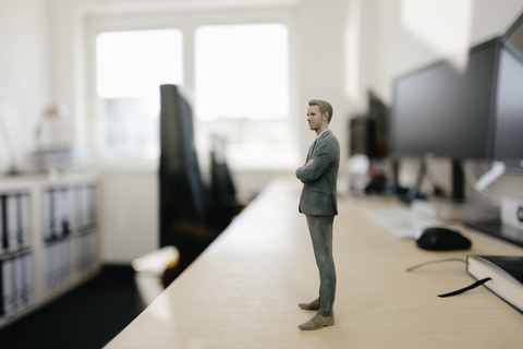 Businessman figurine standing on desk in modern office stock photo